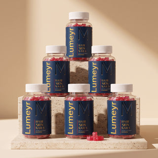 Six bottles of Lumeyr Hair Skin Nails gummies stacked in a pyramid on travertine slabs - 6-month supply